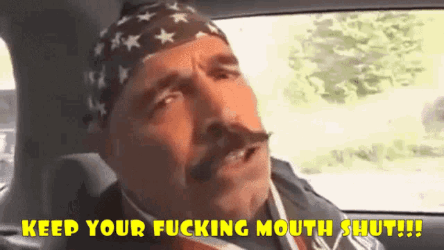 a man with a mustache wearing an american flag headband says keep your fucking mouth shut