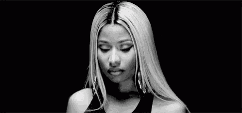 a black and white photo of a woman with long blonde hair and earrings .