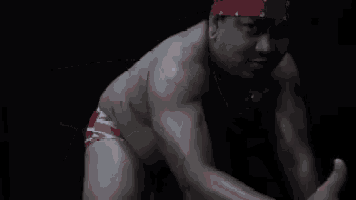a man without a shirt is holding his hands to his chest .
