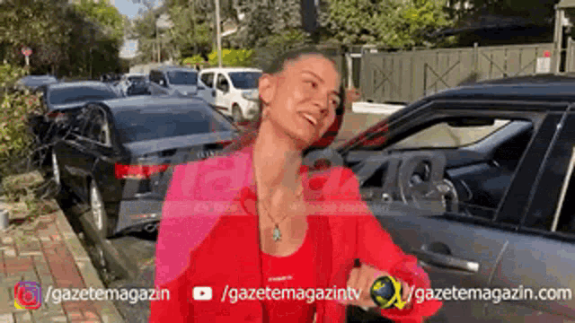 a woman in a red jacket is standing in front of a row of cars ..