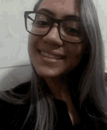a close up of a woman wearing glasses smiling