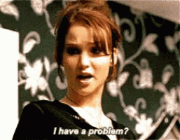 a woman says i have a problem in front of a wall with flowers on it