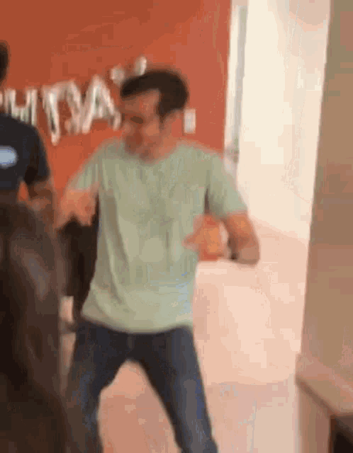 a man is dancing in a room with other people .