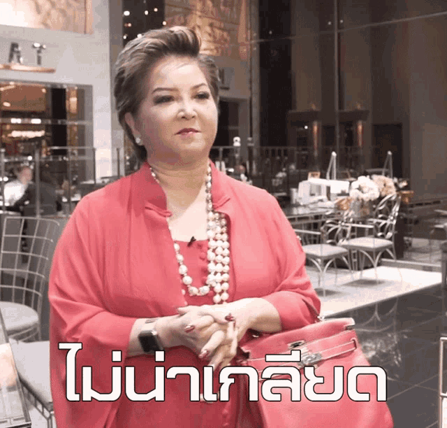 a woman in a red dress stands in front of a sign that says ' i 'm not a celebrity '