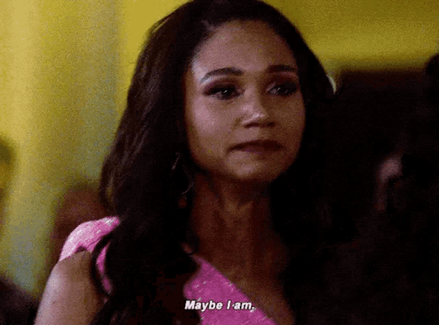 a woman in a pink dress is saying maybe i am