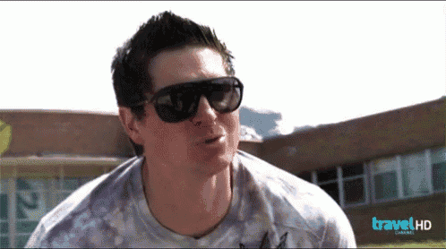 a man wearing sunglasses and a travel hd logo