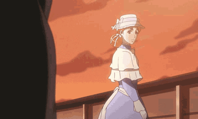 a woman in a blue dress and white hat stands in front of a sunset