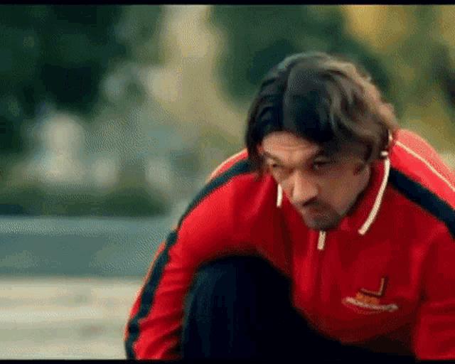 a man wearing a red jacket with the letter l on it