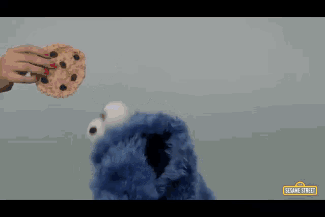 a sesame street advertisement shows a cookie monster eating a cookie