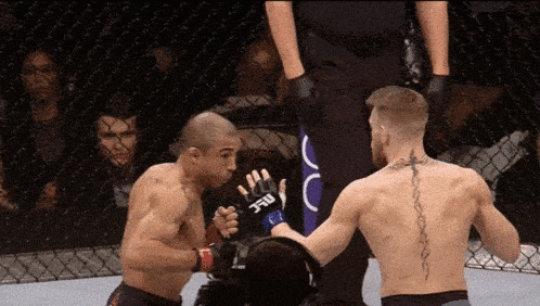 a man with a tattoo on his back is fighting another man in a ufc ring
