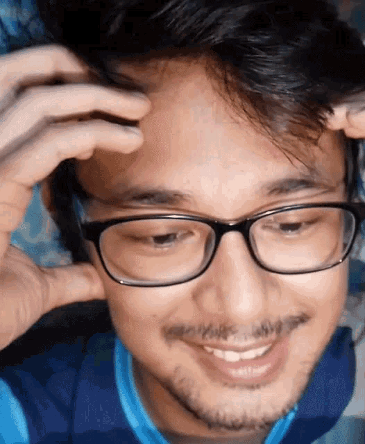 a man with glasses and a beard is smiling