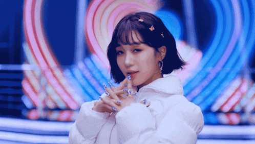 a woman in a white jacket with blue nails