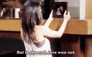 a woman taking a picture of herself with the words but in the end love won out below her