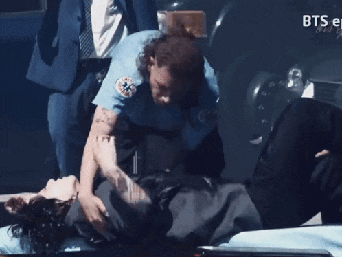 a man is laying on an ambulance with a license plate that says 7h987p2