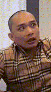 a man in a plaid shirt is making a funny face .