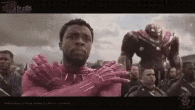 a man in a pink iron man suit is standing in front of a crowd of people .
