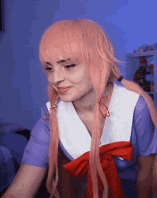 a woman with pink hair is wearing a purple and white shirt