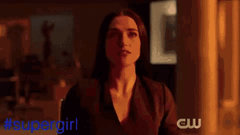 a woman in a black dress is standing in front of a cw logo ..