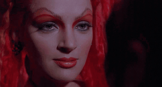 a close up of a woman 's face with red makeup