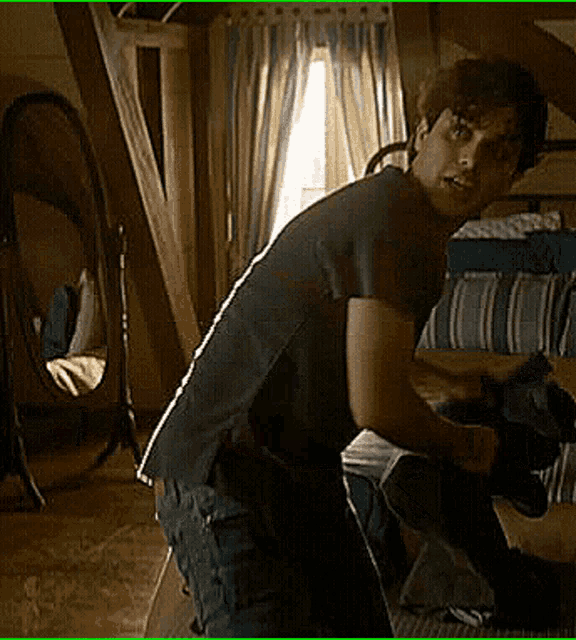 a man in a black shirt is standing in a room with a mirror