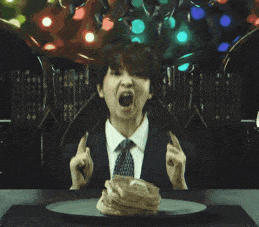 a man in a suit and tie is eating a piece of food on a plate