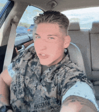 a man in a military uniform is taking a selfie with the name mahexaw on his shirt