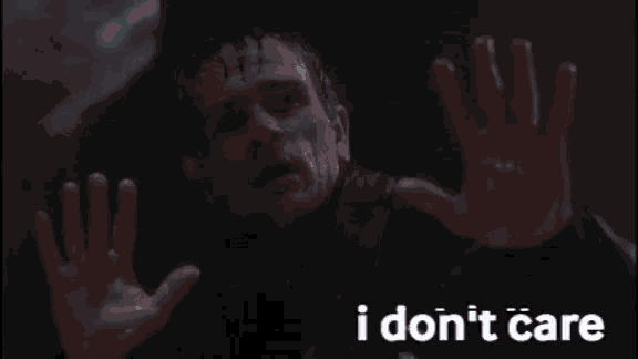 a man 's hands are reaching out in front of a sign that says " i ii don t care "