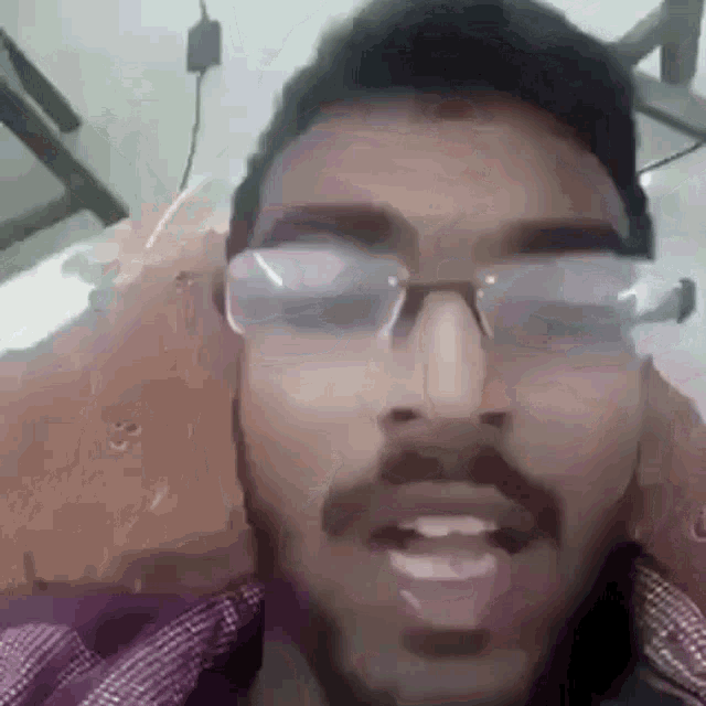 a man with glasses and a beard is talking to someone .
