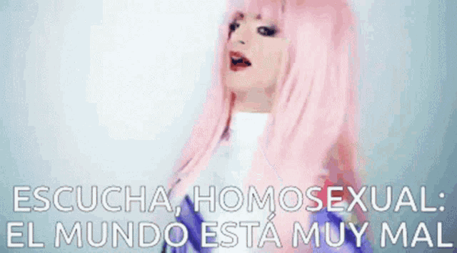 a woman with pink hair is making a face and pointing at something with the words escucha homosexual el mundo esta muy mal in the background .