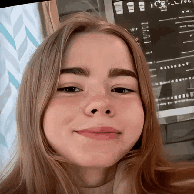 a close up of a girl 's face with a screen behind her that says ' ice '