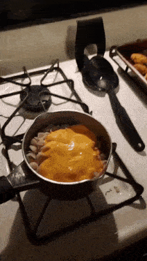 a pot of macaroni and cheese is on a stove top