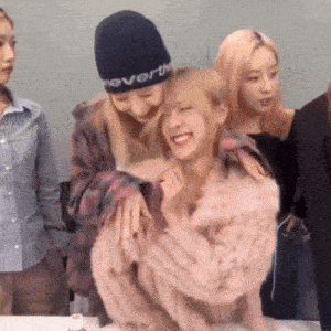 a woman wearing a neverthe hat is hugging another girl