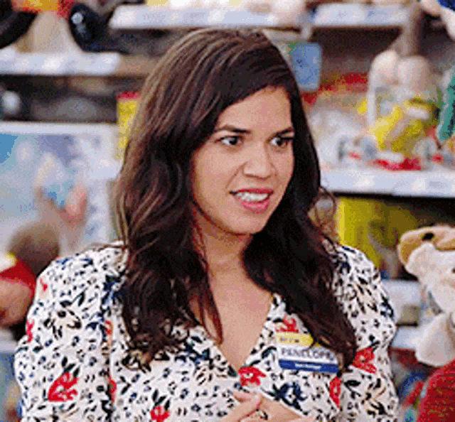 a woman wearing a name tag that says penelope is standing in front of a shelf of stuffed animals .