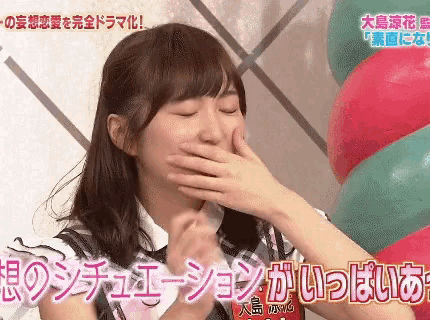 a woman is covering her mouth with her hand in front of balloons in a foreign language .