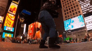 a woman is dancing in front of a building that says express on it