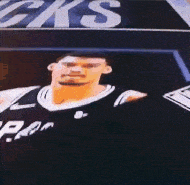 a basketball player is standing in front of a sign that says ' cks ' on it .