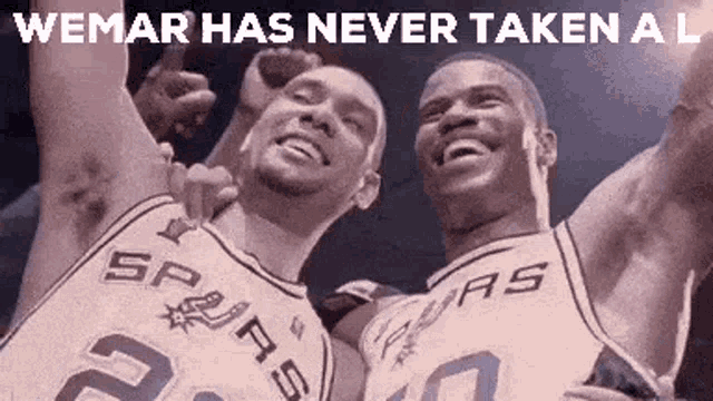 two basketball players are posing for a picture together .