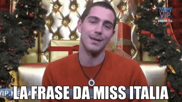 a man sitting in front of a christmas tree with the words la frase da miss italia above him