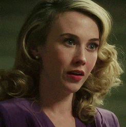 a woman with blonde hair is wearing a purple top