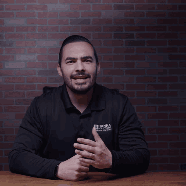 a man wearing a black shirt that says hanna solutions on it