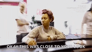 a woman is sitting at a table in front of a mirror and talking to herself .