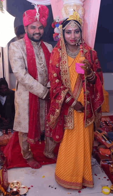 a bride and groom posing for a picture in their wedding outfits