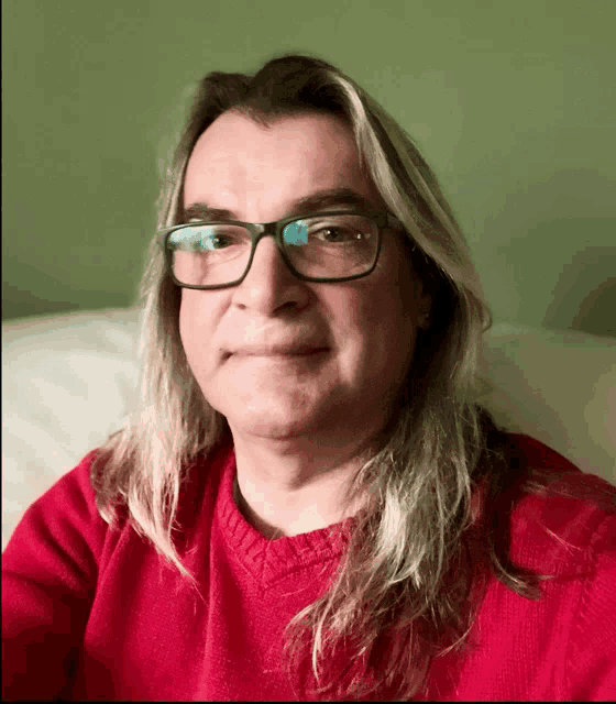 a man wearing glasses and a red sweater