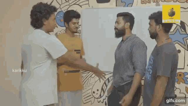 a group of men are shaking hands in front of a whiteboard in a room .