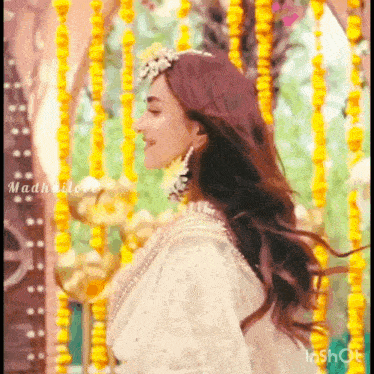 a woman wearing a white dress and a flower crown on her head .