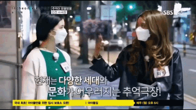 a woman wearing a mask talks to another woman on sbs
