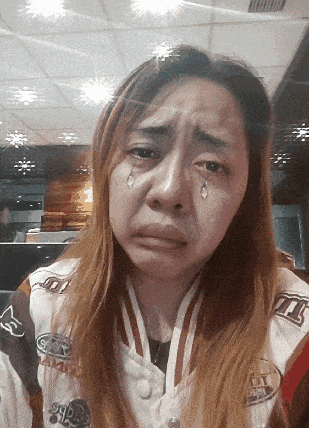 a woman with tears running down her face is wearing a jacket that says m & m 's on the front