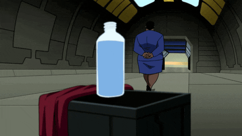 a woman in a blue dress stands in a room with a bottle of water in front of her