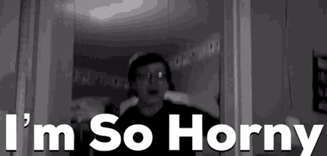 a man is standing in front of a door with the words `` i 'm so horny '' written above him .