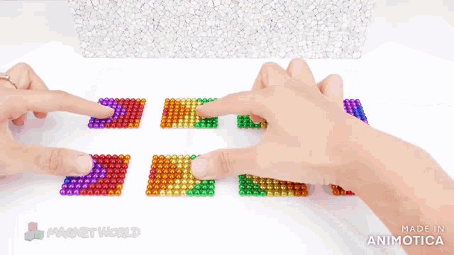 a person is playing with a set of colorful magnet beads